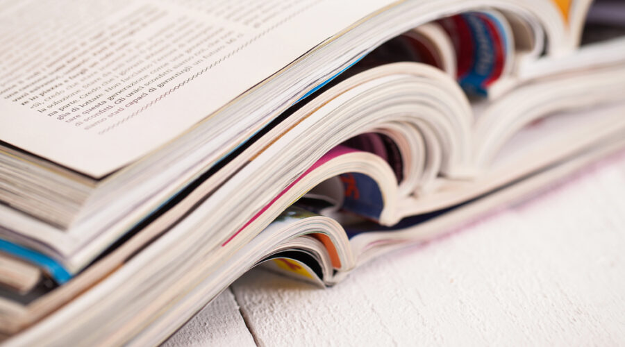 Pile of colorful magazines on a white table