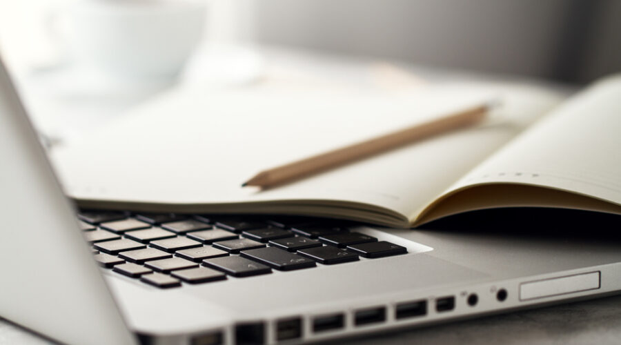Closeup of Workspace with Modern Creative Laptop, Cup of Coffee and Pencils. Horizontal with Copy Space.